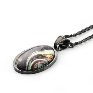 Collier pendentif gemme galaxie ovale, cadre et chaîne en métal noir, détail bijou chic.