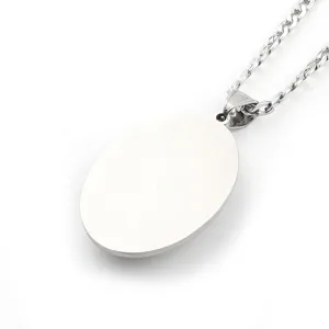 Detailed view of a silver oval pendant necklace with a brushed metal texture on a white chain.