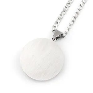 Pendentif rond en acier inoxydable collier gros plan avec chaîne en métal poli et brillant.