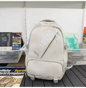 Beige grosser Kapazitaet Schulrucksack mit diagonaler Fronttasche und modernem Buchstabendruck.