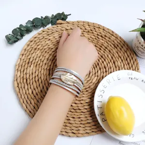 Multilayer leather wrap bracelet with metallic geometric charm and magnetic clasp for women.
