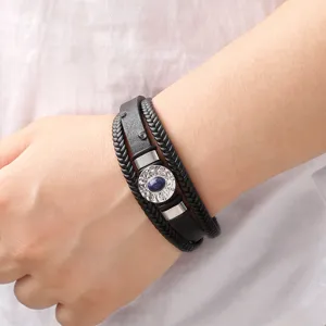 Vue détaillée du bracelet en cuir tressé multicouche avec pierre bleue centrale pour hommes.
