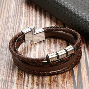 Gros plan sur le bracelet en cuir tressé multicouche avec fermoir aimanté et perles métalliques.