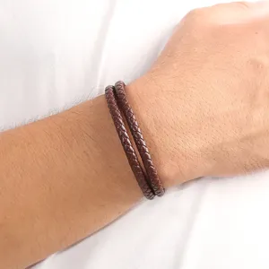 Close-up detail of double layer brown braided leather bracelet for men, simple retro style.
