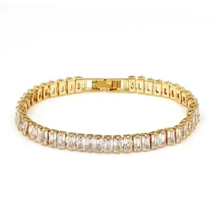 Elegant baguette crystal tennis bracelet detail, sparkling gold-tone metal with secure clasp.