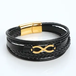 Detail view of multi-layer black braided leather bracelet with gold infinity symbol clasp.
