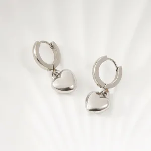 Detailed close-up view of silver heart drop hoop earrings showcasing polished metal texture.