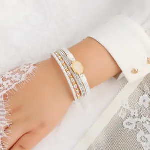 Nahaufnahme des mehrlagigen weißen Lederarmbands mit funkelnden Kristallen und feinem Golddetail.