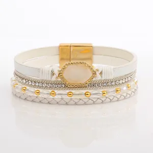 Nahaufnahme Detail des mehrschichtigen geflochtenen Lederarmbands mit Strass und Goldschließe.
