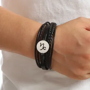 Close-up detail of the multi-layer black leather bracelet featuring a stainless steel Capricorn charm.