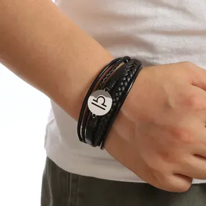 Detailed shot of men's black leather braided bracelet featuring a stainless steel Libra charm.