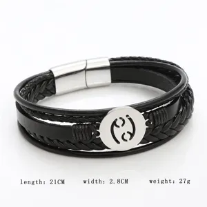 Close-up view of men's black leather braided bracelet with stainless steel zodiac charm.