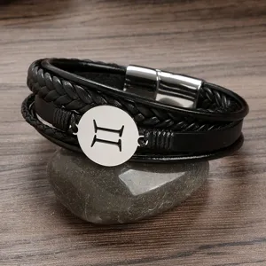 Detail view of men's leather braided bracelet with stainless steel zodiac charm and clasp.
