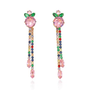 Primo piano di orecchini lunghi con frutta in zircone colorato, catena di pietre preziose.