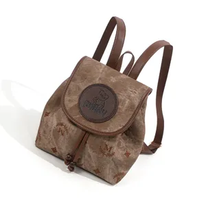 Vintage bruine canvas rugzak met lederen bandjes en monogram patroon voor dagelijks reizen.