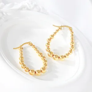 Close-up detail of stylish 18K gold plated stainless steel graduated bead hoop earrings.