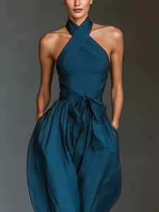 Detailed view of the dark teal halter cross strap jumpsuit with waist tie and side pockets.