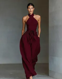 Women's criss-cross halter jumpsuit detail, stylish belted waist and wide-leg linen silhouette.