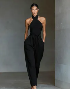 Detailed view of women's black cross halter tie waist wide leg jumpsuit in elegant setting.