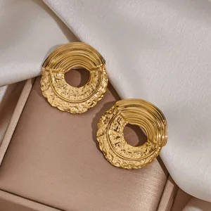 Detailed shot of textured gold-plated stainless steel hoop earrings, elegant niche design jewelry.