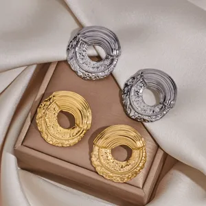 Detail view of trendy abstract metal stainless steel stud earrings in gold and silver colors.