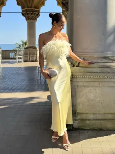 Detail shot of the strapless satin long dress with fluffy feather trim outdoors.