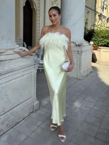 Detail view of the yellow strapless satin long dress featuring fluffy feather trim.