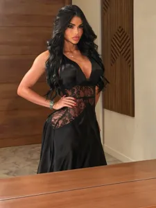 Vestido largo negro de satén con encaje transparente, cuello en V y talle con abertura.