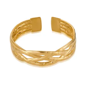 Detail view of gold stainless steel geometric open cuff bracelet with irregular woven design.