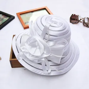 Closeup detail of elegant white organza sun hat for women, featuring delicate floral ribbon bow.