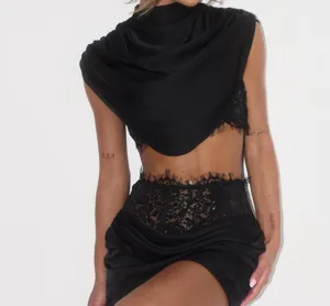 Black two piece set detail featuring cowl neck draped top and lace boned ruched mini skirt.