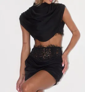 Close-up detail of the black two-piece outfit featuring lace trim, boned corset, and cowl neck.
