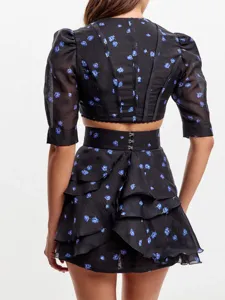 Λεπτομερής όψη γαλλικού φλοράλ σετ με crop top με φουσκωτά μανίκια και πολυεπίπεδη φούστα.