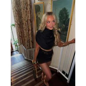 Stylish elegant black two-piece set featuring a stand collar top and lace trim mini skirt.
