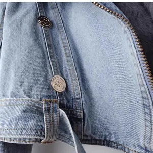 Close-up detail van dames denim jas met metalen rits en decoratieve knopen