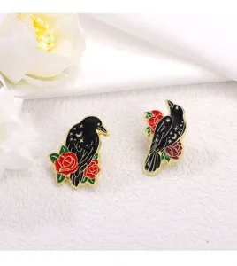Enamel crow brooch with red roses and starry sky details, gothic clothing accessory badge.