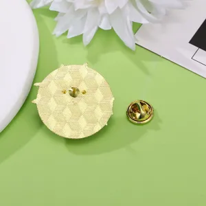 Retro spilla in metallo dorato con trama geometrica e chiusura di sicurezza a farfalla.