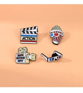 Cartoon cinema theme enamel pin set featuring cute popcorn projector and clapperboard metal badges.
