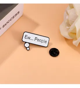 Detail shot of a creative English speech bubble enamel brooch pin, fashion clothing alloy badge.