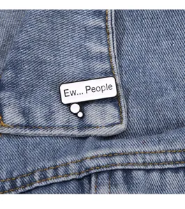 Close-up detail of the funny speech bubble enamel pin with text, stylish clothing decor.