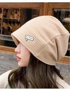 Detailed shot of knitted hat with stylish speech bubble brooch pin accessory closeup.