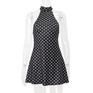 Gros plan sur les détails de la mini-robe licou à pois noirs et blancs sans manches.