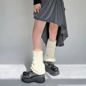Detalle de calentadores de piernas de felpa blanca esponjosa con zapatos de plataforma.
