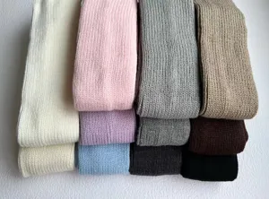 Knitted leg warmers stacked in various colors, soft warm fabric for autumn and winter daily wear.
