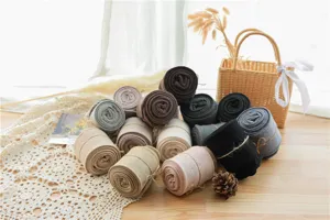 Détail de collants en coton côtelé montrant des leggings roulés multicolores.