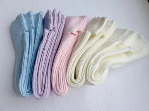 Close-up detail of soft knit leg warmers in pastel colors, cozy winter stacking socks.