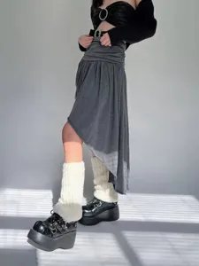 Primer plano de calentadores blancos esponjosos con textura suave para conjuntos de invierno.