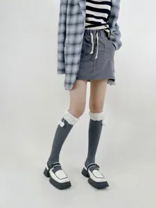 Detailed shot of Japanese style warm cotton knee high socks featuring fluffy pom pom cuffs for winter.