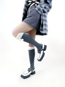 Detail view of Japanese winter warm cable knit calf socks featuring plush fleece cuffs and cute pom-poms.