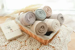 Vue détaillée de collants en coton côtelés roulés dans un panier douillet avec déco naturelle.
